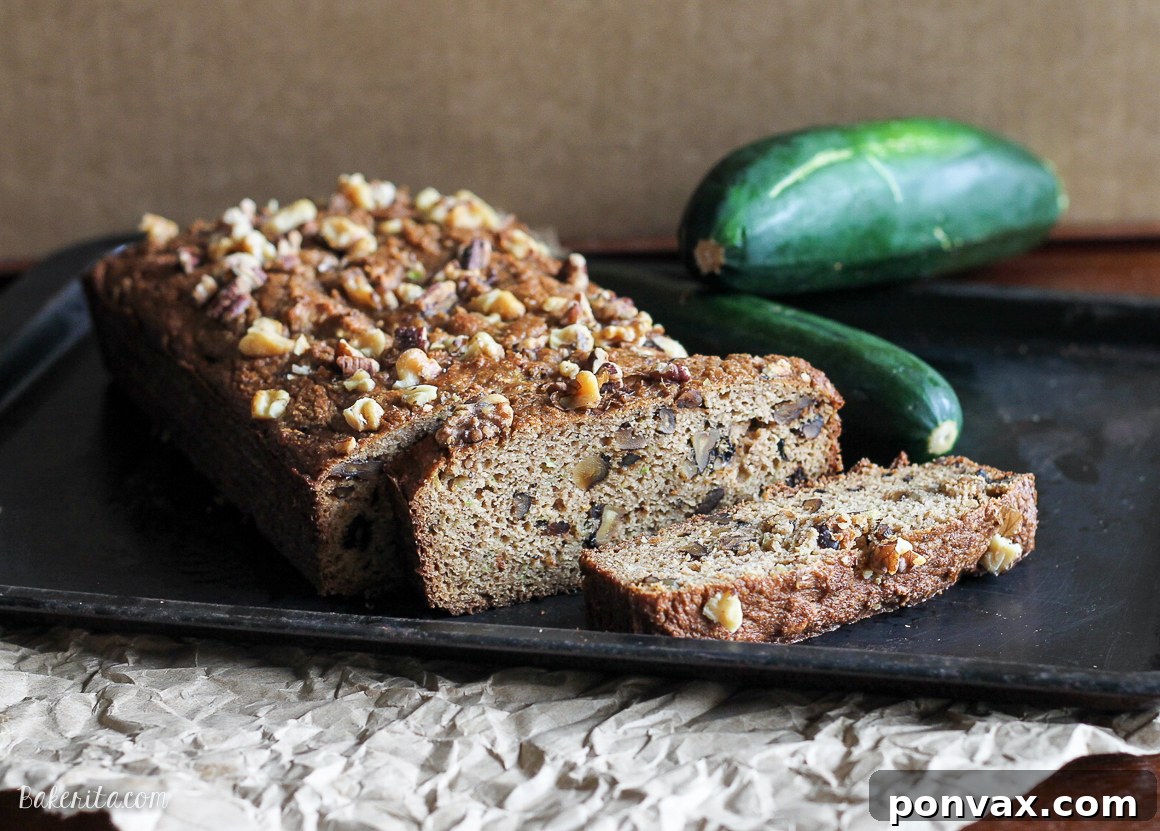 Moist Paleo Zucchini Walnut Bread 3 Close-up of a slice of Paleo Zucchini Bread showing its tender crumb and visible pieces of toasted walnuts.