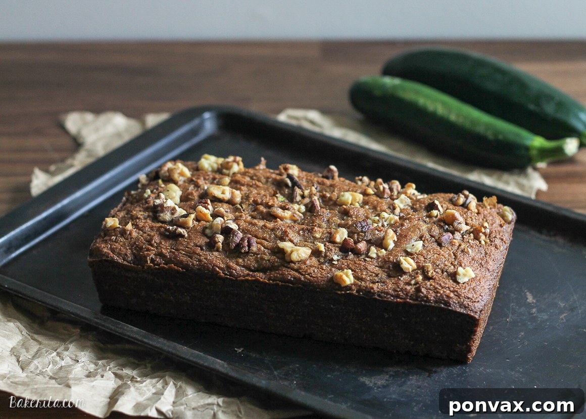 Moist Paleo Zucchini Walnut Bread 4 Close-up of a slice of Paleo Zucchini Bread on a cutting board, showcasing its texture and golden crust.