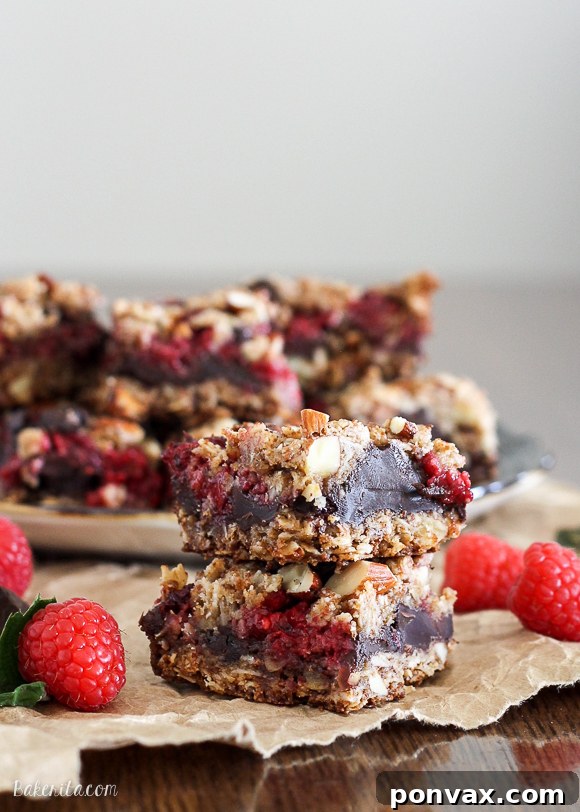 These Raspberry Chocolate Chunk Bars have a crust that doubles as a crumble topping and are loaded with raspberries, dark chocolate, and almonds. This easy recipe is gluten free, refined sugar free, and vegan!
