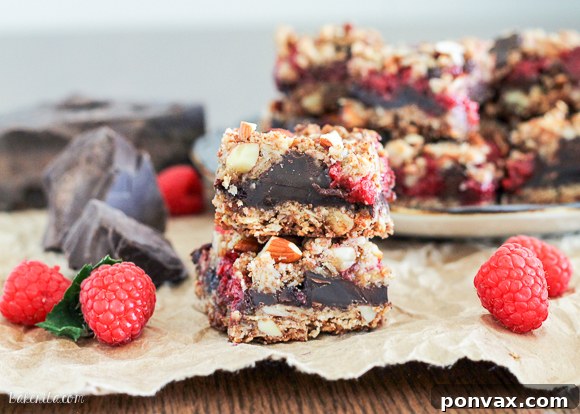 These Raspberry Chocolate Chunk Bars have a crust that doubles as a crumble topping and are loaded with raspberries, dark chocolate, and almonds. This easy recipe is gluten free, refined sugar free, and vegan!