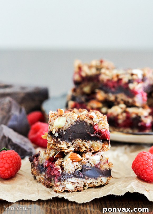 These Raspberry Chocolate Chunk Bars have a crust that doubles as a crumble topping and are loaded with raspberries, dark chocolate, and almonds. This easy recipe is gluten free, refined sugar free, and vegan!