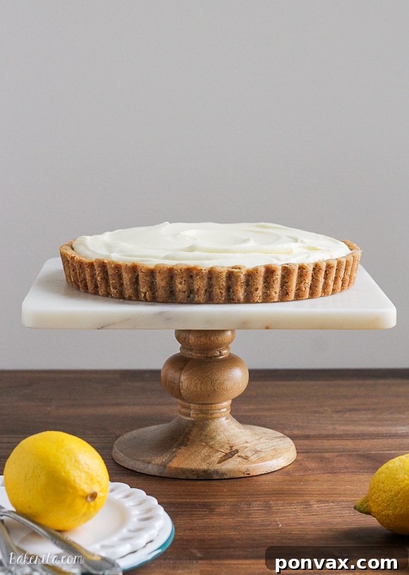 A slice of Frozen Lemon Cream Tart with a delicate Browned Butter Crust, garnished with lemon zest, looking incredibly refreshing on a hot day.