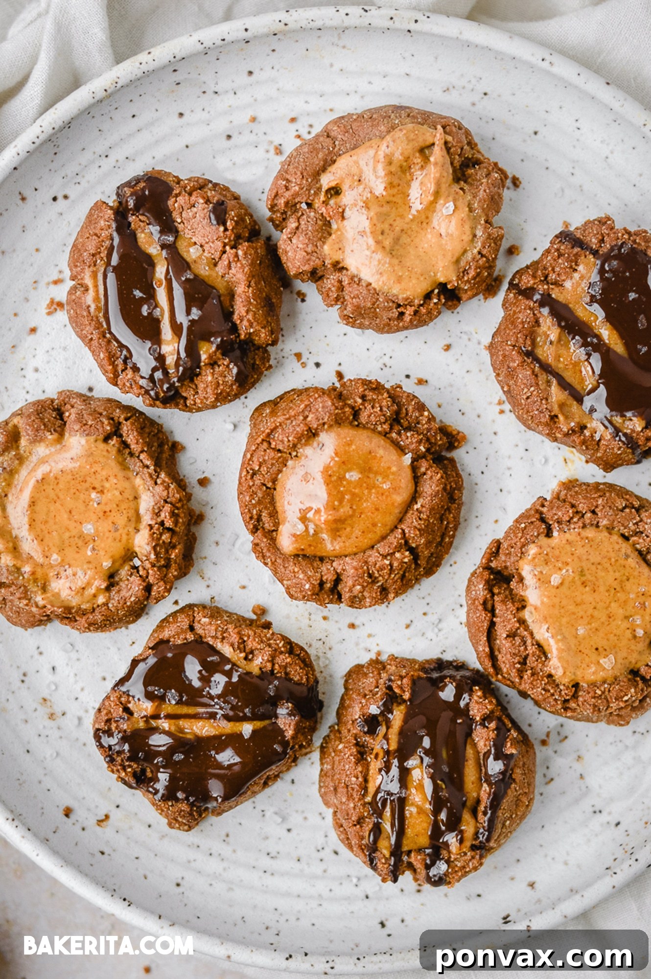 A tray of freshly baked chocolate thumbprint cookies, ready for their almond butter filling.