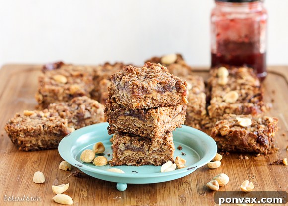 Close-up of a partially baked tray of Peanut Butter & Jelly Crumb Bars, showing the creamy peanut butter and jam filling before the final crumb topping.