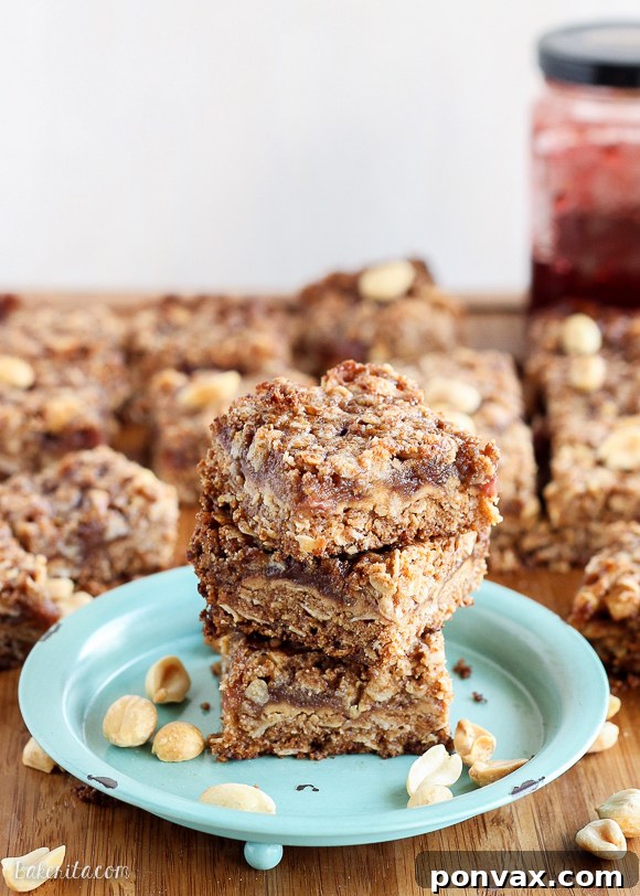 Overhead shot of freshly baked Peanut Butter & Jelly Crumb Bars in a pan, cut into squares, ready to be enjoyed.