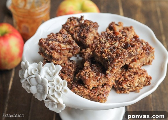 Close-up of golden-brown Caramel Apple Crumb Bars with a visible apple and caramel filling, perfect for a cozy fall treat.