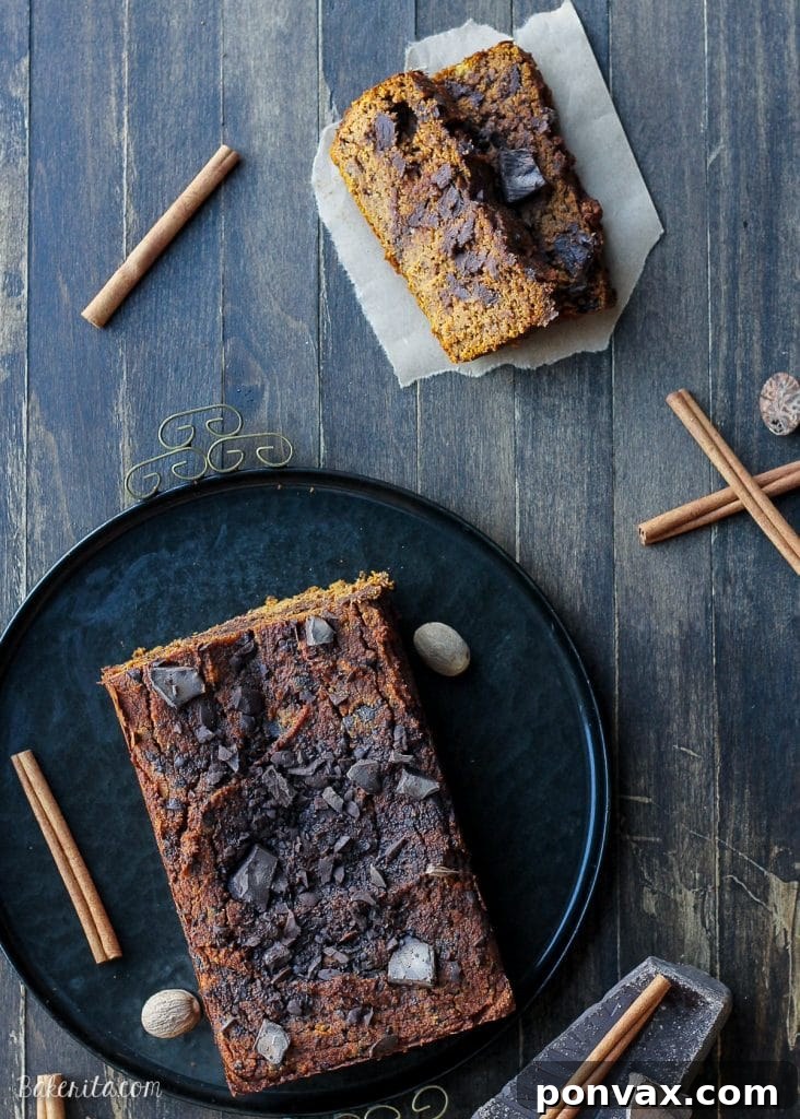 Four slices of Paleo Chocolate Chip Pumpkin Bread stacked on a plate, ready to be served.