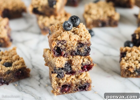 Stacked Blueberry Crumb Blondies on a white plate, ready to be served