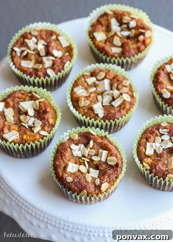 Cozy Gluten-Free Apple Pumpkin Spice Muffins 4 Stack of freshly baked Gluten-Free Pumpkin Apple Muffins on a wooden board, ready for breakfast.