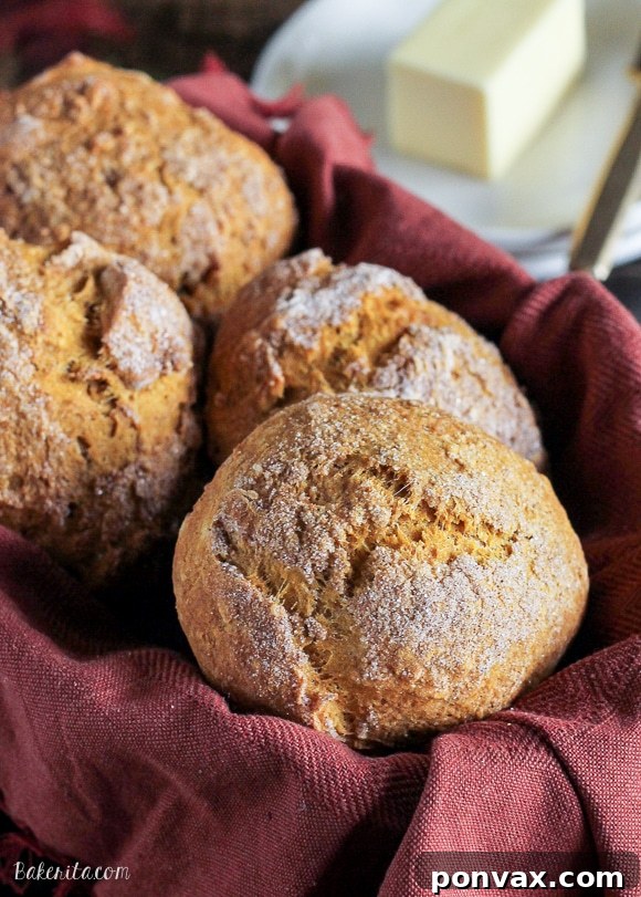 Freshly baked Cinnamon Sugar Pumpkin Rolls, golden brown and sprinkled with cinnamon sugar, served warm for breakfast.