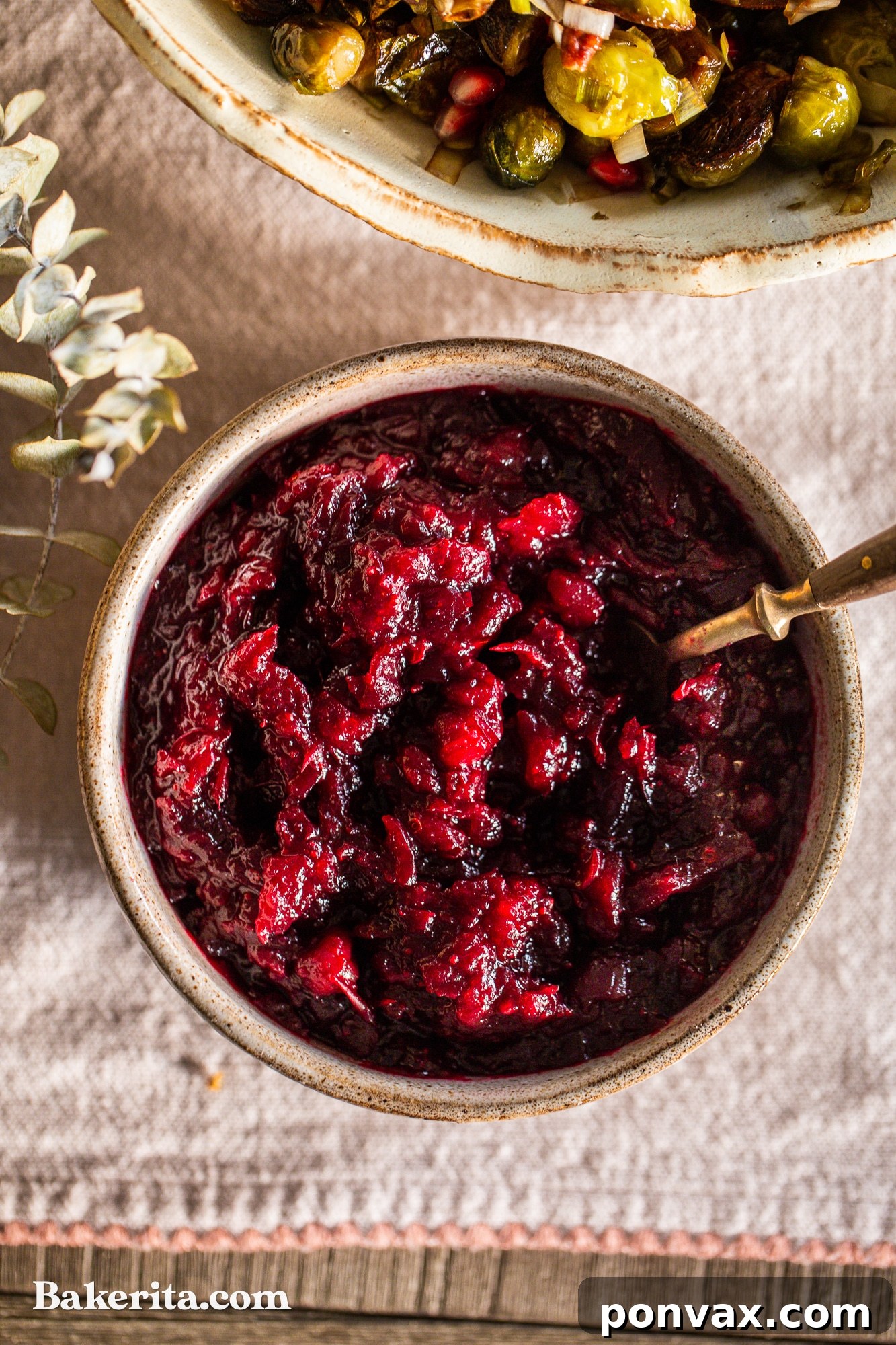 Naturally Sweetened Paleo Cranberry Relish 5 Overhead shot of a rustic Thanksgiving table setting featuring a small bowl of healthy paleo cranberry sauce as a vibrant side dish.